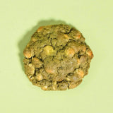 Matcha White Chocolate New York Cookie by Crumbs & Doilies, a green cookie with white chocolate chips on a light background.